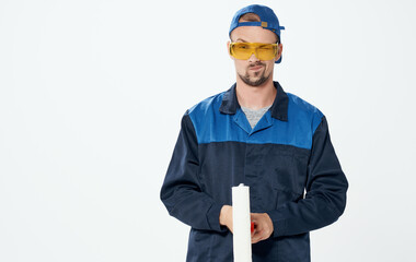 Man repairing paint roller blue suit and cap glasses