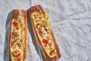 Bread boats stuffed with ham, egg, green onion and cheese for breakfast