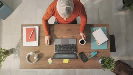 man working from home at her desk opens laptop computer top view overhead shot,zoom out of businessman opening notebook and start typing writes email surfs the internet drinks coffee - Powered by Adobe