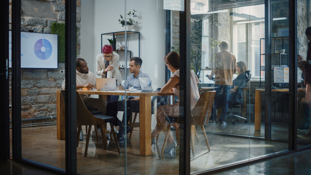 Diverse Group of Professional Businesspeople Meeting in the Conference Room. Creative Team Discuss App Design, Analyze Data, Plan Marketing Strategy for Social Media. Stylish Busy Business Office