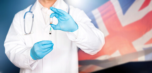 Close up of hands of doctor preparing for vaccination, UK flag in the background