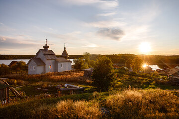 Obraz premium Russian village Orthodox church at sunset