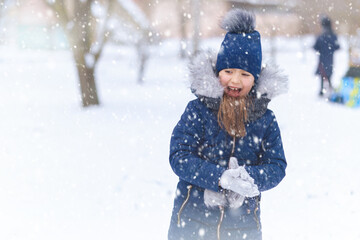 child girl playing with snow in winter outdoor and having fun on snowy winter