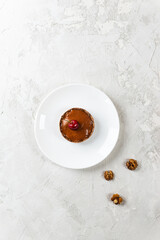 Banana cake with cherries on a white plate. Raw dessert, healthy food. Sugar, gluten and lactose free. Vertical orientation, top view.