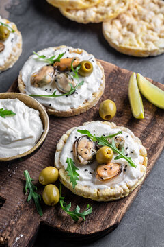 Bruschetta with mussels, cheese, crisp breads Mussels bruschetta, toast with soft cheese and arugula, banner, top view, vertical image, place for text