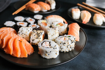 Lunch or dinner at a Japanese restaurant. Set  sushi maki rolls  with salmon, avocado, cream cheese. Sushi menu. Japanese food. Black background. Top view. Food delivery coronavirus