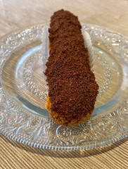 Eclair au chocolat sur une assiette