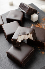 Closeup of delicious candies with chocolate glaze and soft filling on the dark surface
