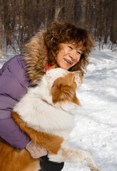 Adult woman is walking with red big dog. Winter park. Dogs training
