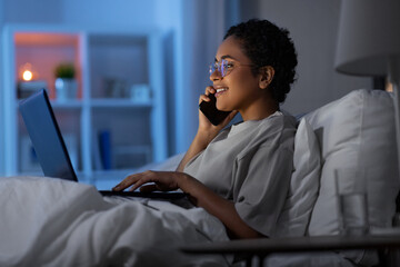 technology, internet, communication and people concept - happy smiling young african american woman...