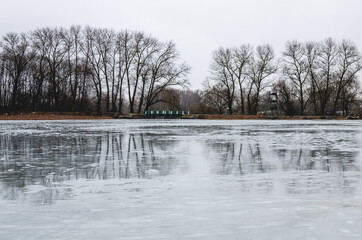 Frozen lake in early spring. Ice hasn't melted yet, cloudy day in early spring