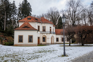 Baroque white benedictine monastery Brevnov with church, Pavilion Vojteska, Garden and park, abbey under snow in winter day, Prague, Czech Republic