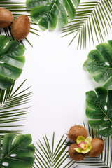 Tropical summer frame border with coconuts, orchid flower and palm leaves on bright background with copy space. Creative nature visual trend concept. Minimal flat lay.