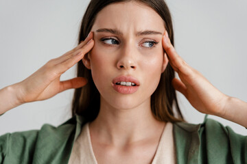Displeased caucasian girl with headache rubbing her temples