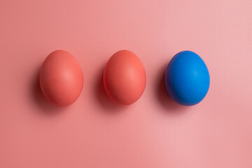 Pink and blue eggs. Eggs on a pink background. Three colored chicken eggs. Easter decorations.