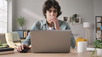 frustrated upset man sits at his desk opens laptop zoom out motion,young male student feel stressed using notebook computer looking annoyed at the screen sitting at home office table failure concept - Powered by Adobe