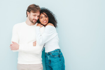 Naklejka premium Smiling beautiful woman and her handsome boyfriend. Happy cheerful multiracial family having tender moments on grey background in studio. Multiethnic models hugging. Embracing each other.Love concept