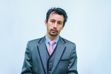 Funny unshaven man in suit with tie on gray background
