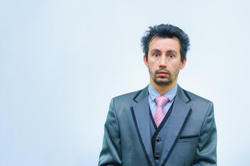 Funny unshaven man in suit with tie on gray background