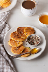 Golden pancakes with honey, various seeds and coffee.