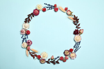 Frame of beautiful dried flowers on light blue background, flat lay. Space for text