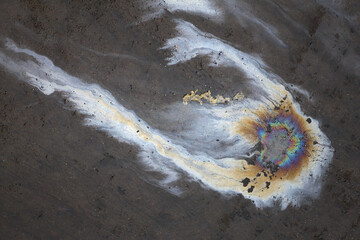 Oil spill on polluted concrete after petroleum leaking; color photo.