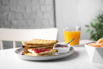Tasty toasts with jam served on white wooden table indoors. Space for text