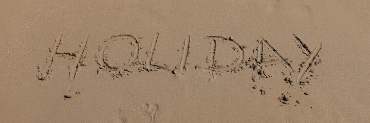 Word leave and footprints write on sand. Coast of soft sand and sea waves.