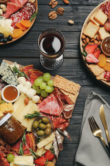 Assorted appetizers served on black wooden table, flat lay