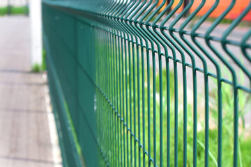 Green steel wire fence with rods. Protecting private property. Selective focus