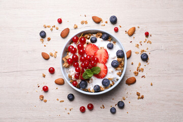 Delicious granola with fruits and nuts on wooden table, flat lay