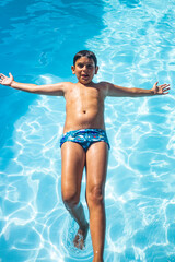 Young boy jumping on a pool