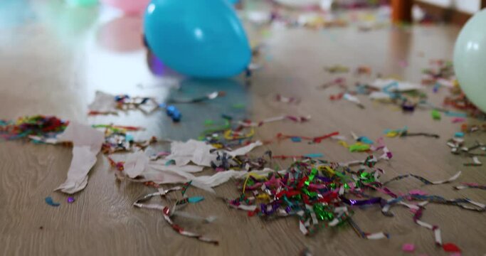 Floor with after party celebration with empty bottles, wine glass and party decorations, messy living room interior, After party chaos, birthday