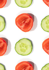 Cucumbers and tomatoes pattern of fresh vegetables sliced 
on a white background