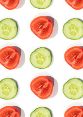 Cucumbers and tomatoes pattern of fresh vegetables sliced 
on a white background