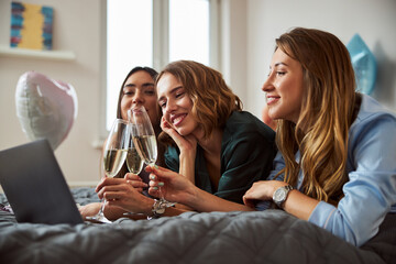 Three females clinking glasses of sparkling wine