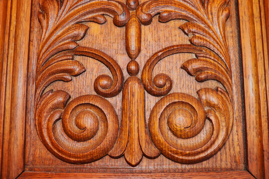 Carving on the front of an antique wooden grandfather clock in Germany.