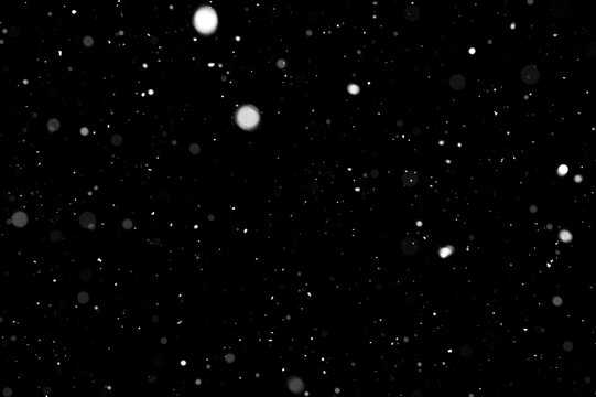 Bokeh of white snow on a black background. Snowfall - design element.