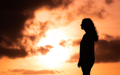 Woman enjoying sunset, silhouette at Sao Miguel island at the Azores.