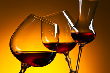 Glasses of brandy or whiskey on a yellow background.