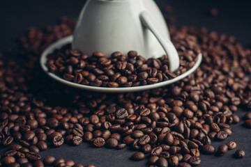 coffee grain on inverted mug and saucer on gray Arabica table