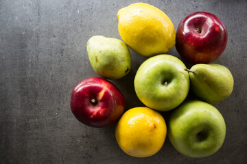 Seasonal fruits on a table. Close up photo of fresh organic fruits. Water drops on fruit's skin. Healthy eating concept. 