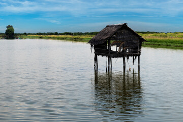 A hut in the middle of the water The backdrop is a reservoir.