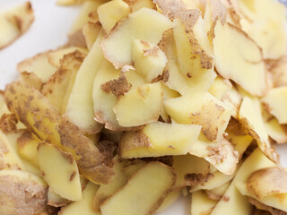 Peeling potatoes on a plate.