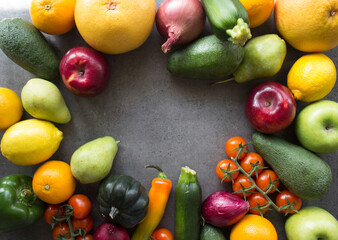 Colorful frame or border made of fresh seasonal vegetables.  Dark grey textured background with copy space.  healthy eating concept. 