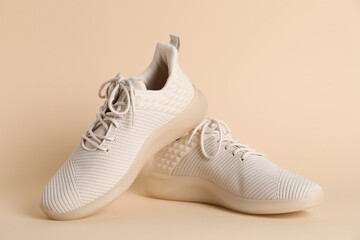 Pair of stylish sport shoes on beige background