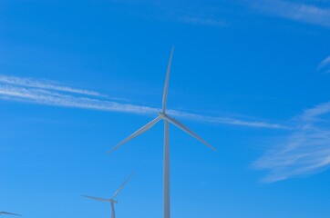 windmill farm on snowy mountain in northern Norway in bright sunshine and blue sky backdrop