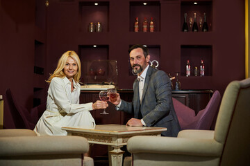 Happy couple enjoying drinks and posing for a camera