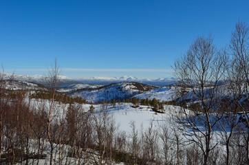 Deep snow covered mountain range on a sunny day in Northern Norway.