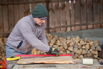 Carpenter measuring and drawing walnut wood